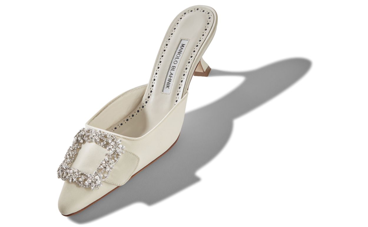 Delphine Bloom White Jewel Buckle Mules – front three-quarter view showing white jewel buckle, crystal buckle, almond toe…