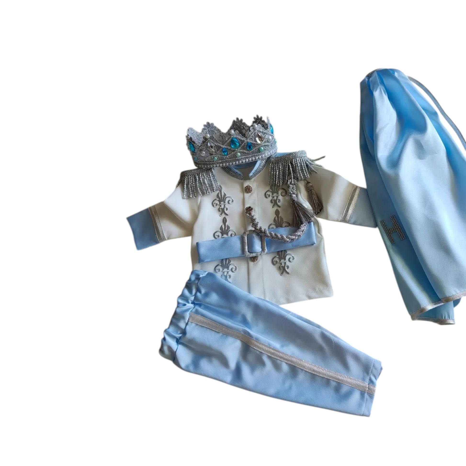 baby boy wearing nan prince outfit with cape and crown birthday photoshoot