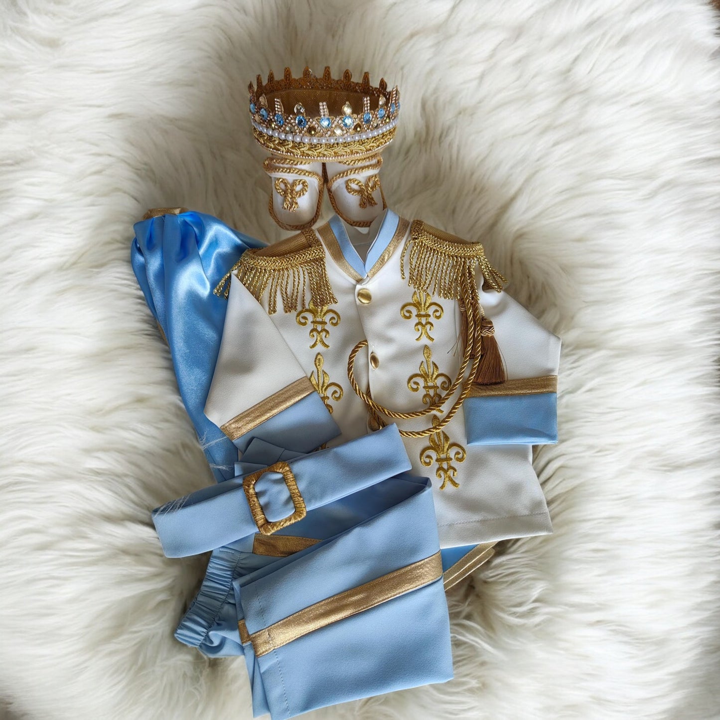 baby boy wearing nan prince outfit with cape and crown birthday photoshoot
