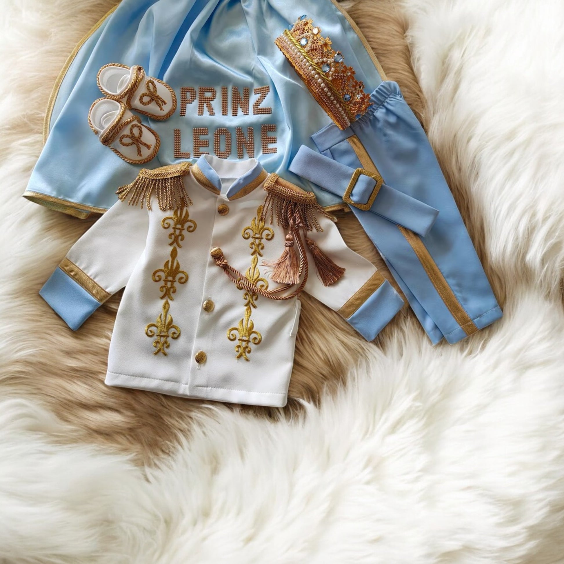 baby boy wearing nan prince outfit with cape and crown birthday photoshoot