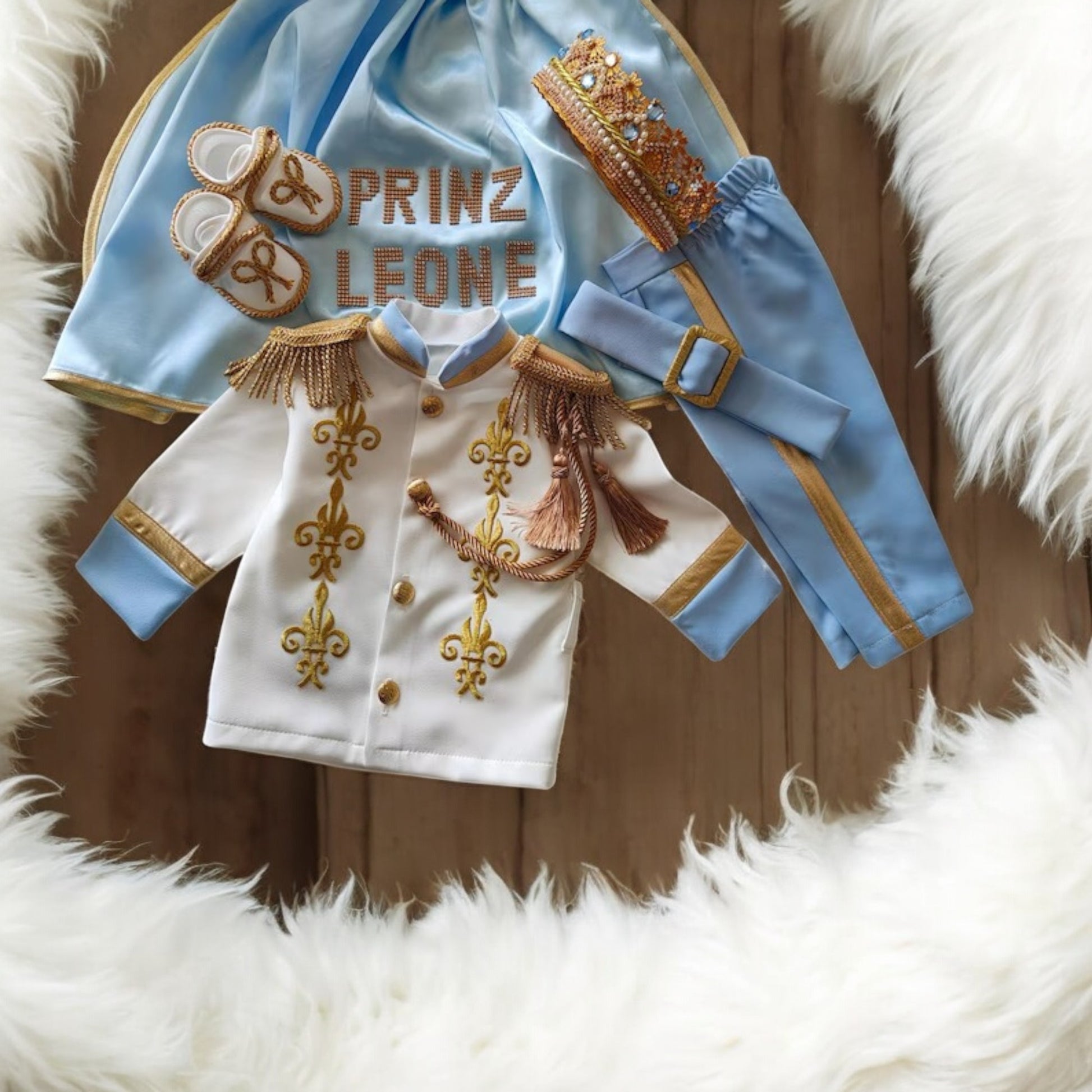 baby boy wearing nan prince outfit with cape and crown birthday photoshoot